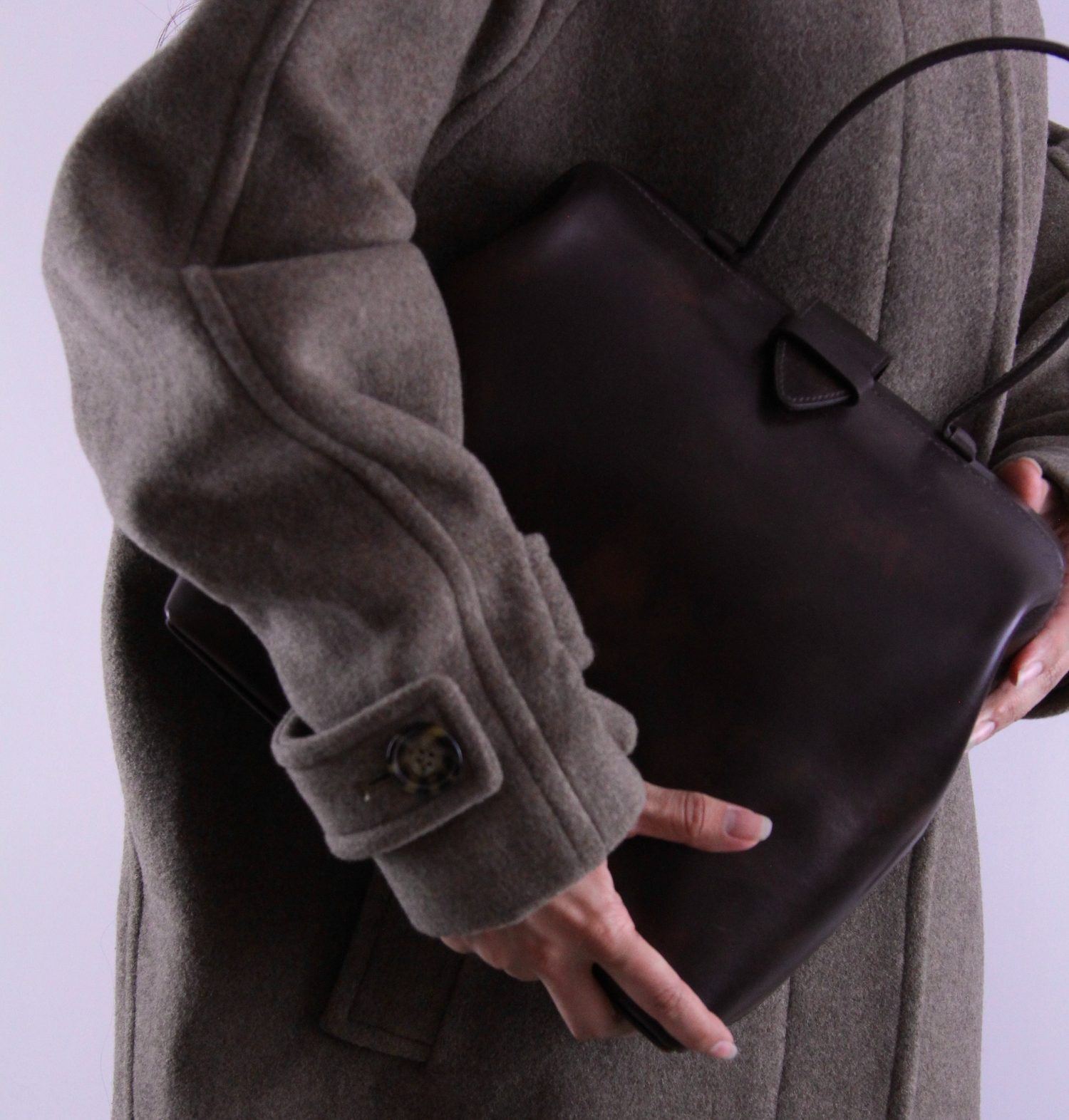 The Physician, a structured dark espresso leather bag carried under the arm