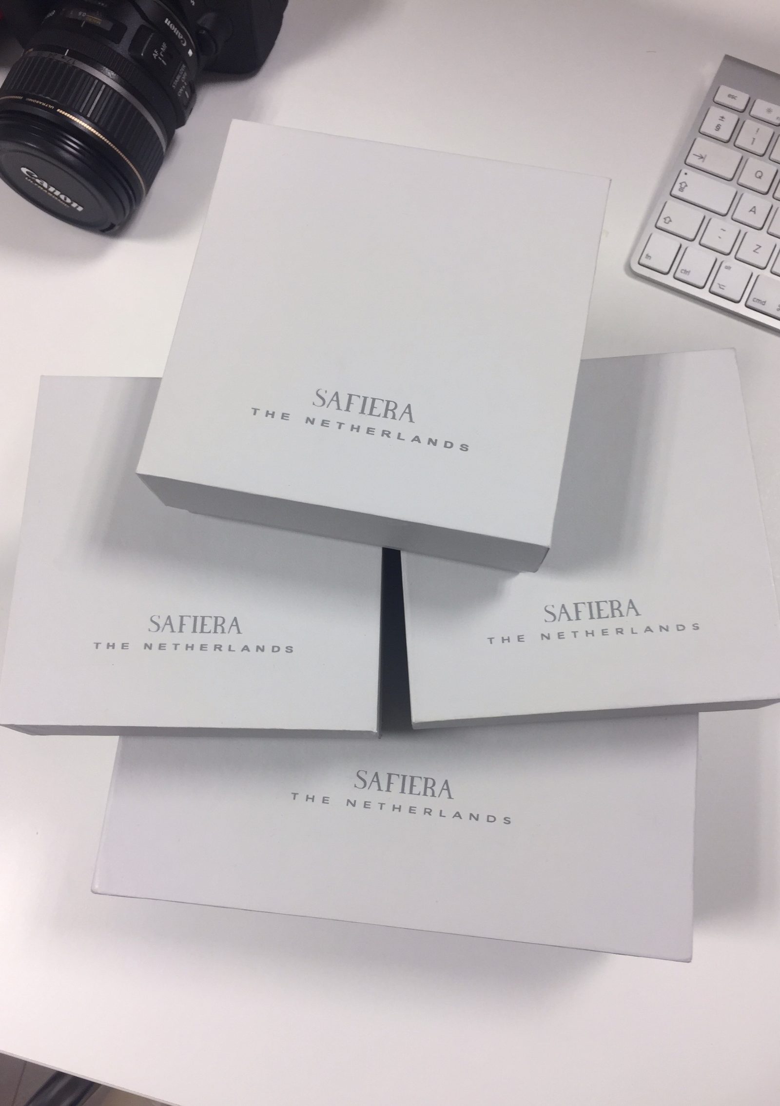 Safiera gift boxes embossed 'Safiera, The Netherlands', stacked on the studio desk