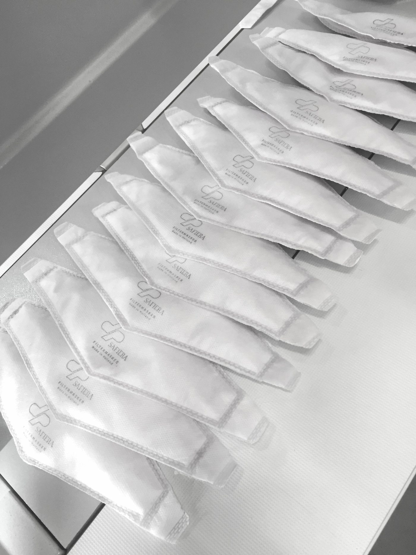 Rows of white SAFIERA filter facemasks laid out in production